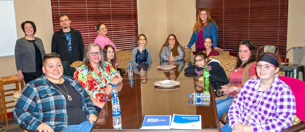 Group of ASUMH students with Brooks Jeffrey staff sitting in conference room