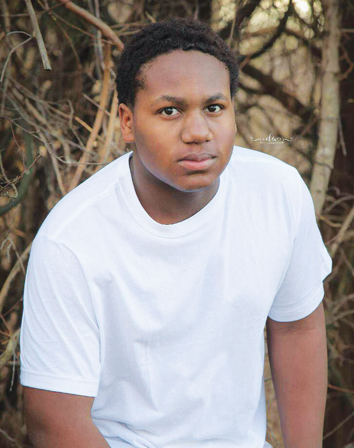 Jayln Cogshell senior portrait outside with woods in background