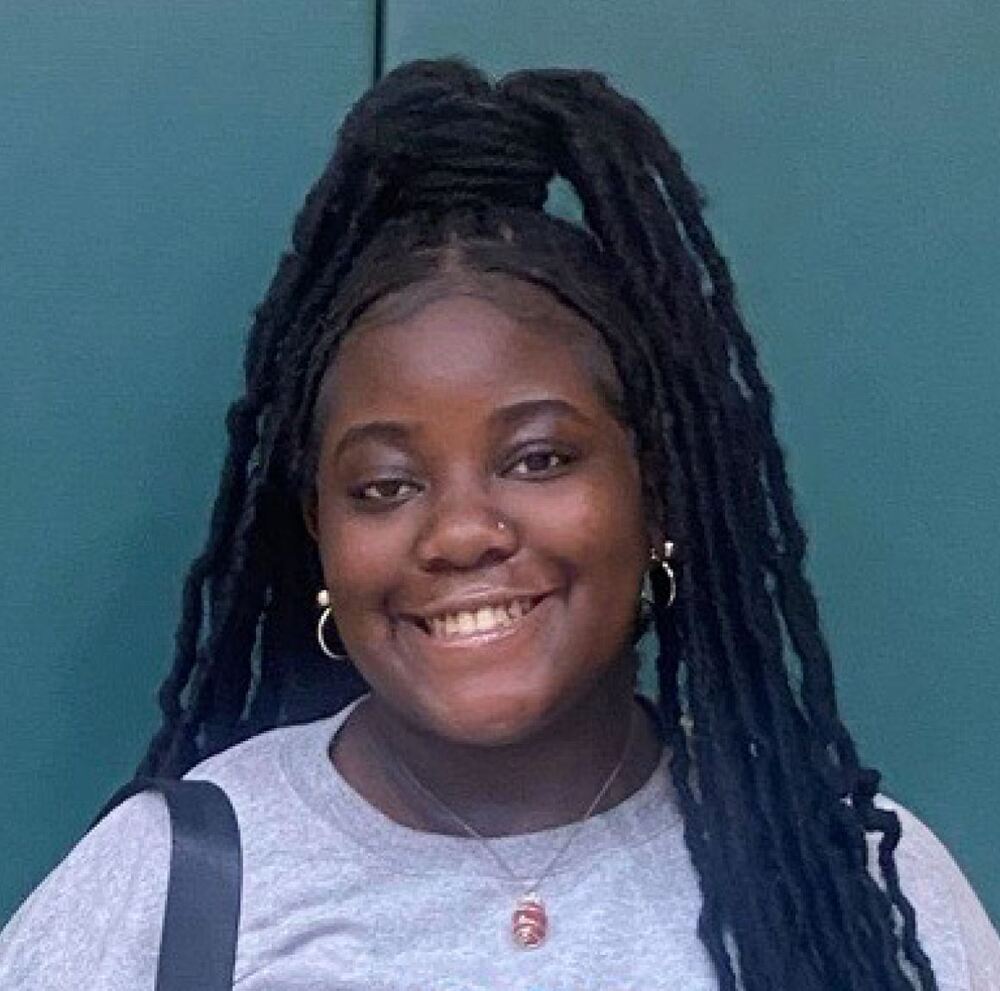 Jordyn Robinson in casual shirt, hair in ponytail, smiling at camera