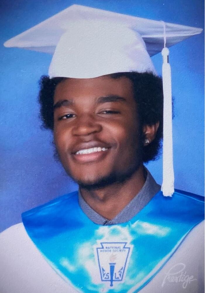 Graduation portrait of Nyviair Davis in cap and gown smiling at camera